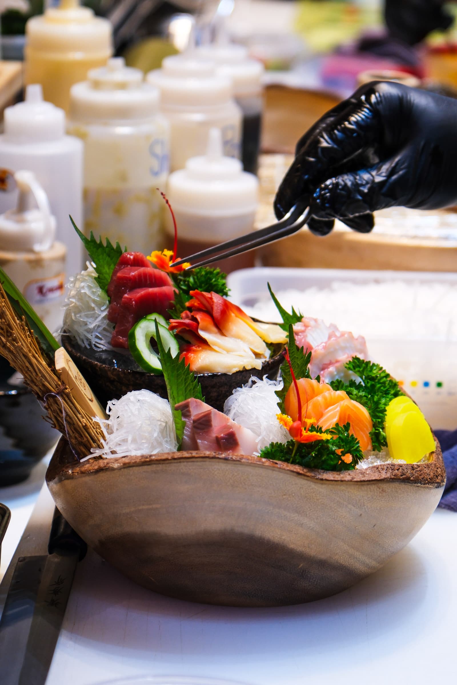 Chef plating a colorful sashimi bowl